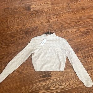 Cream colored turtle neck with checker pattern